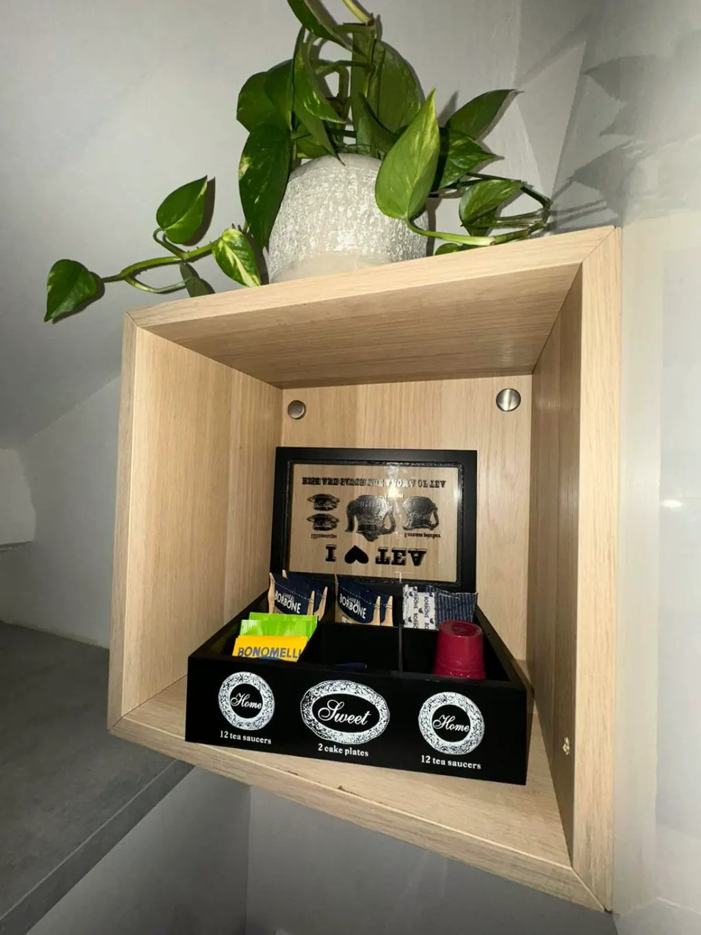 Mensola in legno con il kit di benvenuto: caffè, tè e tisane